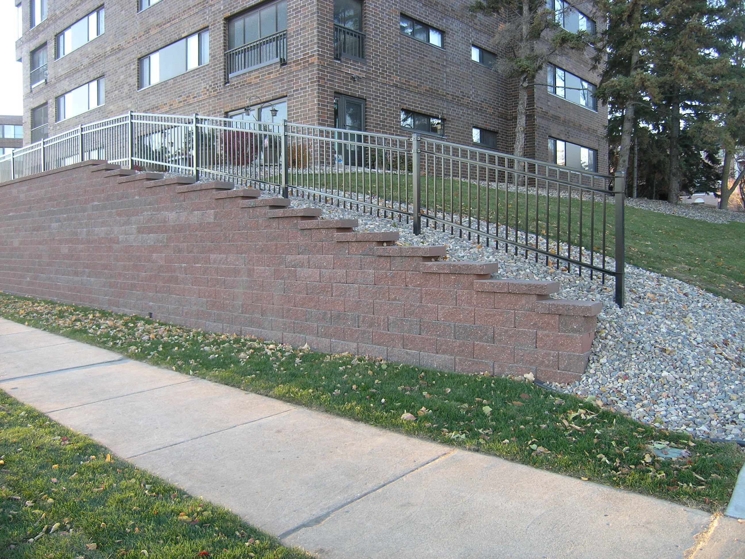 The new wall has a stepped-down transition along the slope.